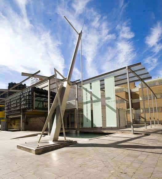 Entrada del museo con escultura metálica en primer plano