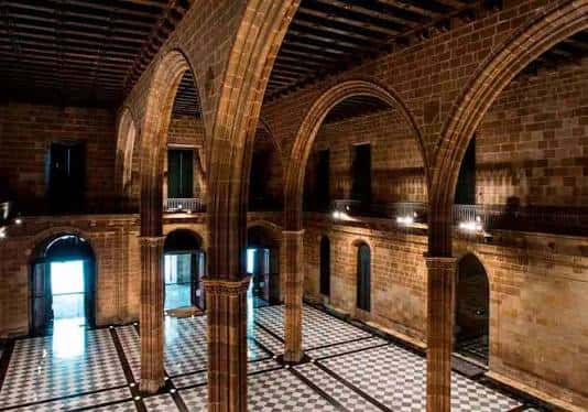 Sala principal de la Llotja de Mar con bóvedas góticas y suelo a cuadros