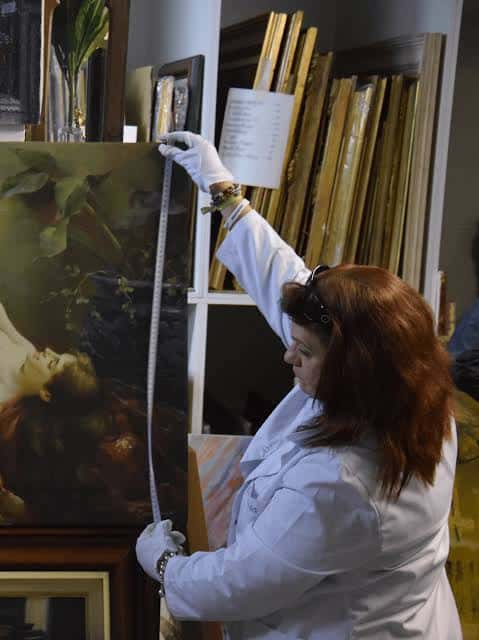 Detalle de una obra enmarcada siendo preparada para exhibición en el espacio cultural