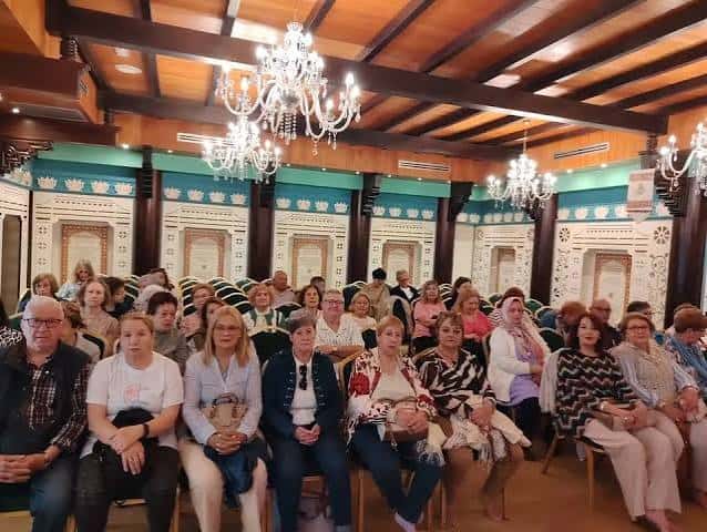 Interior del salón principal con decoración tradicional y público asistiendo a un evento