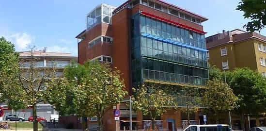 Fachada principal del edificio con grandes ventanales de cristal en Sant Boi