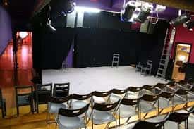 Escenario vacío en Sala Tarambana con iluminación profesional y gradas para espectadores