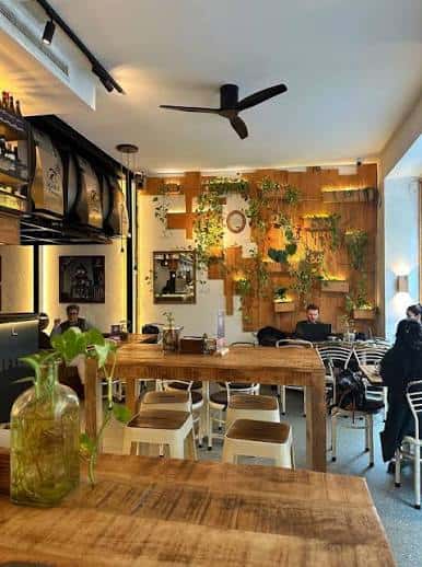 Vista interior del restaurante Abonavida con decoración de plantas en pared de madera