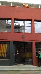 Fachada exterior del Club Muntanyenc Sant Cugat con su distintivo color rojo y entrada principal