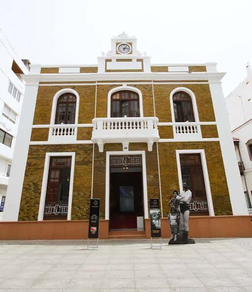Vista frontal de La Casa Amarilla en Arrecife con fachada de azulejos amarillos y detalles blancos