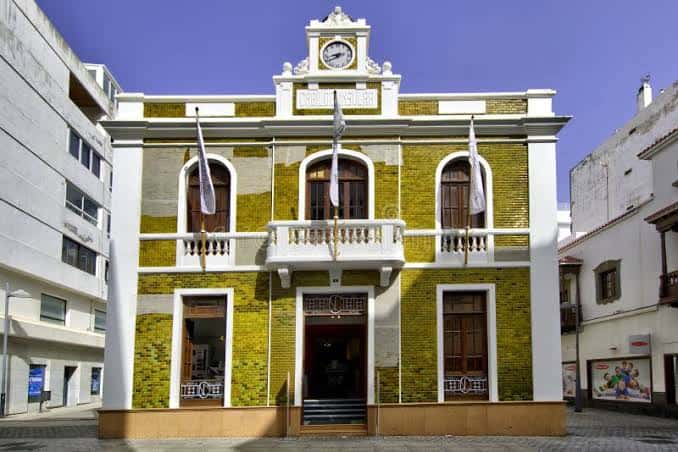 Fachada principal de La Casa Amarilla con banderas colgando del balcón central