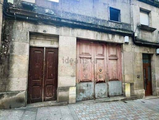 Fachada de nave industrial en Carretera de Camposancos con puertas de madera y piedra