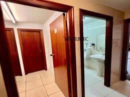 Interior de oficina o local comercial con puertas de madera y baños visibles