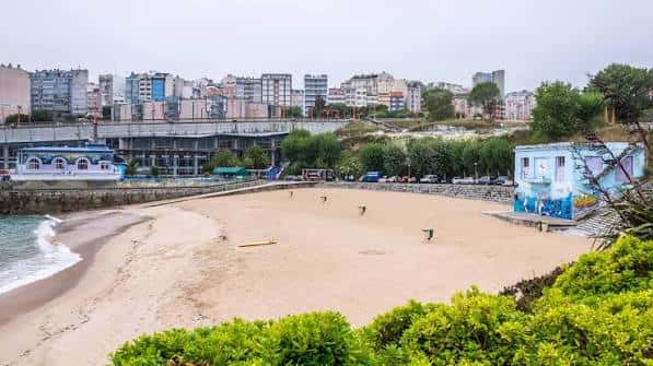 Playa de San Amaro con edificios urbanos al fondo