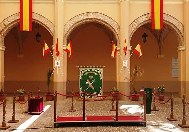 Patio interior decorado para evento oficial con banderas y alfombra roja