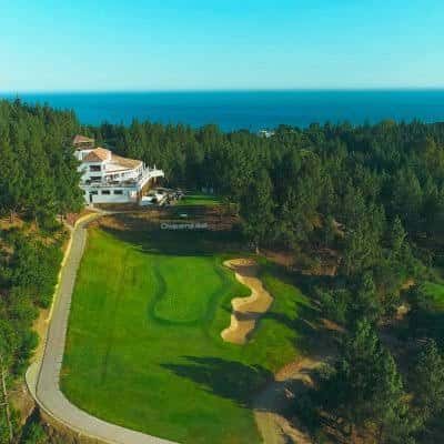 Vista aérea del campo de golf con el club house y el mar al fondo