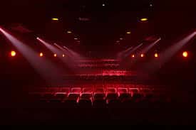 Escenario iluminado con luces rojas y butacas vacías