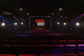 Aula magna con pantalla que muestra el nombre del teatro