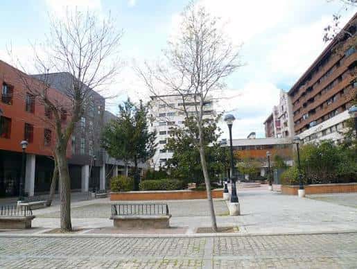 Vista general de la Plaza Juan de Austria en León con edificios residenciales y zonas peatonales