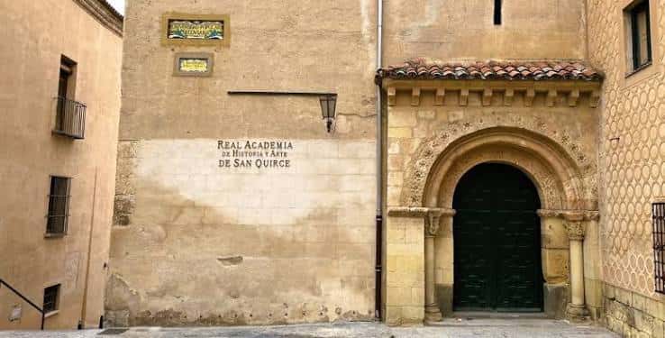 Detalle de la entrada con arco románico y placa identificativa