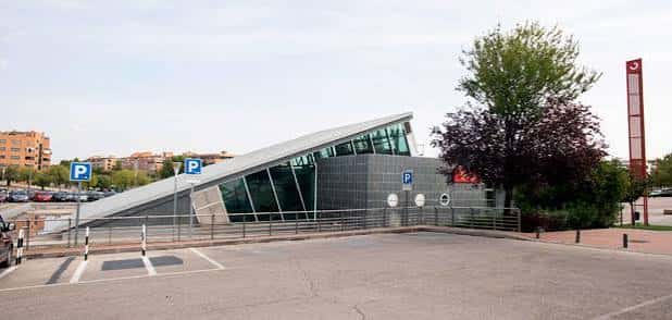 Fachada lateral de la estación con rampa de acceso y señalización de aparcamiento