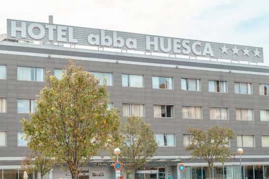 Detalle de la fachada superior del hotel mostrando el letrero 'HOTEL abba HUESCA' y las estrellas