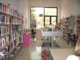 Interior de la biblioteca con estanterías y zona de lectura