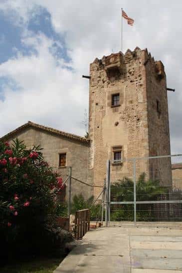 Fachada principal de la masía con bandera catalana y entorno ajardinado