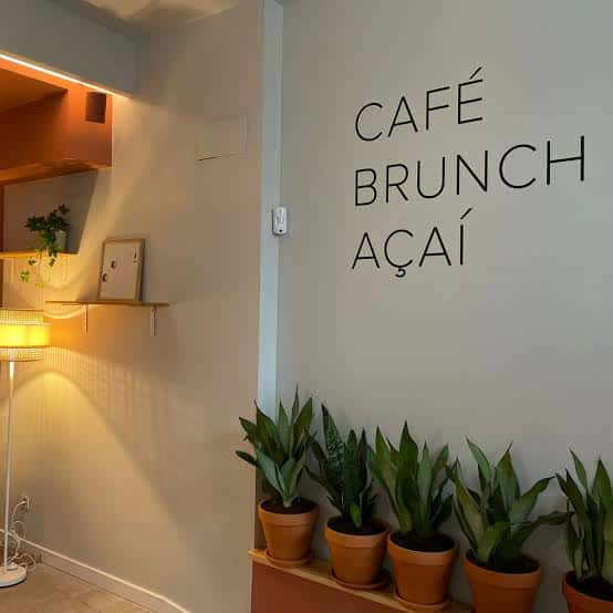 Interior del café con decoración moderna y plantas en macetas