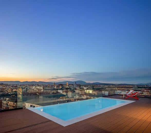 Piscina en la azotea con vistas panorámicas de Vitoria al atardecer