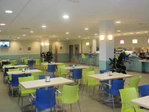 Sala de comedor del CRE Alzheimer con mesas y sillas de colores