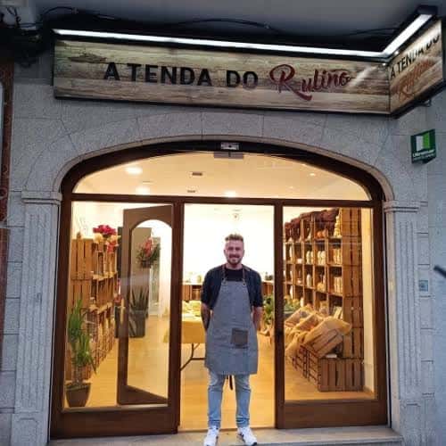 Fachada de A Tenda do Ruliño en Ferrol con el nombre visible y un empleado en la entrada