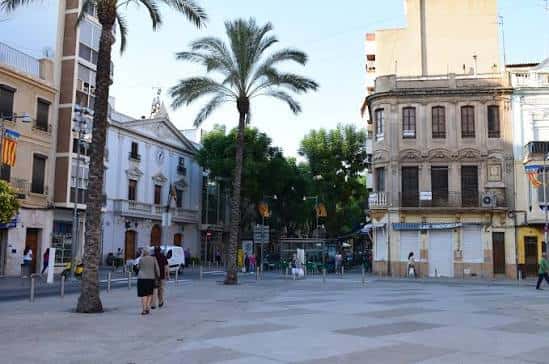 Plaza Mayor de Torrent con palmeras y edificios históricos al atardecer