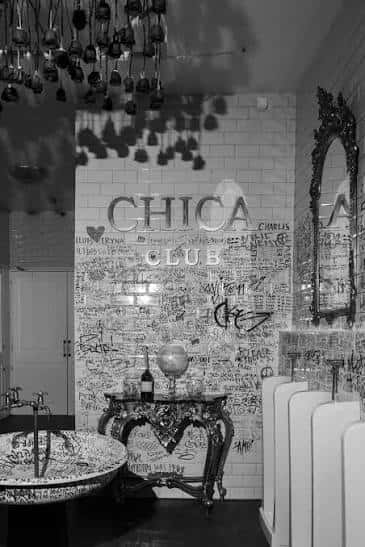 Baño decorado del Chica Club con espejo antiguo y detalles artísticos