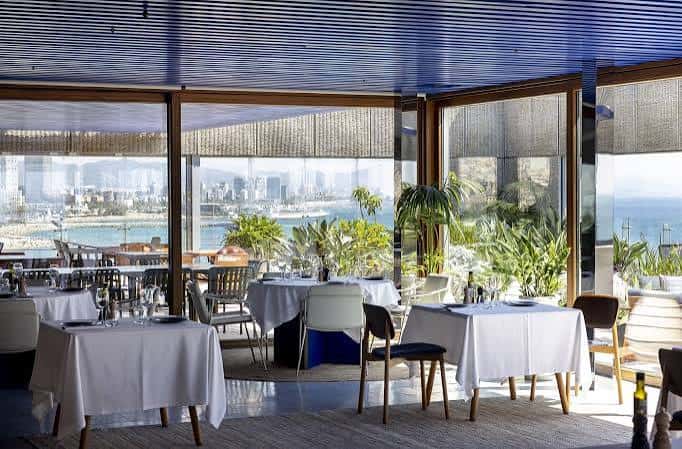 Interior del restaurante Azul Rooftop con mesas dispuestas y vista al mar