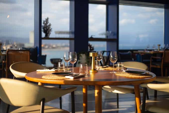Mesa redonda decorada en el interior del restaurante con vistas a la bahía