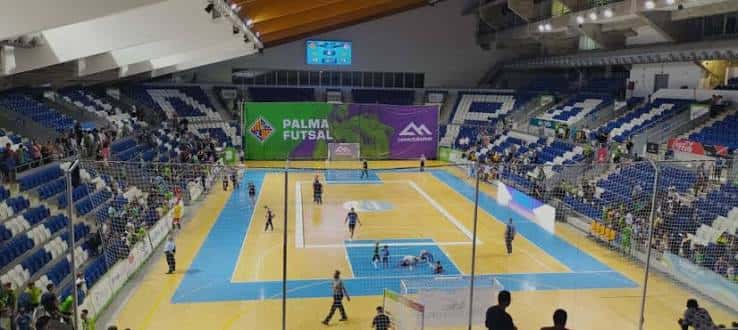 Interior del polideportivo durante un partido de fútbol sala con espectadores