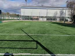 Vista lateral del complejo deportivo mostrando una cancha interior y exterior