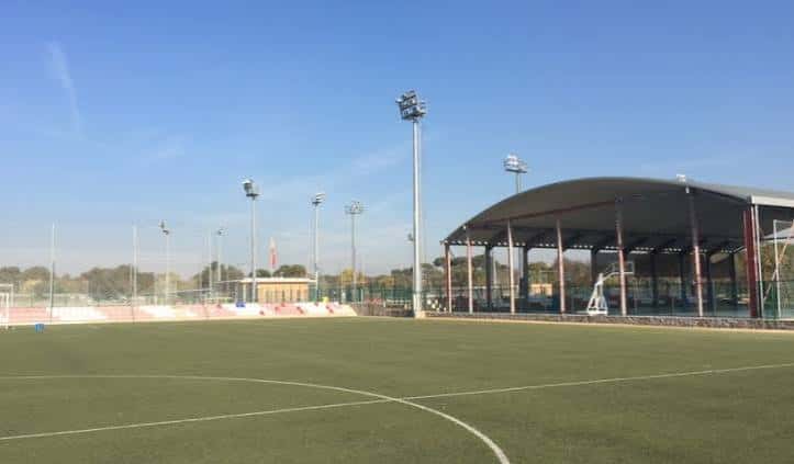 Cancha de fútbol con estructura de sombra y torres de iluminación