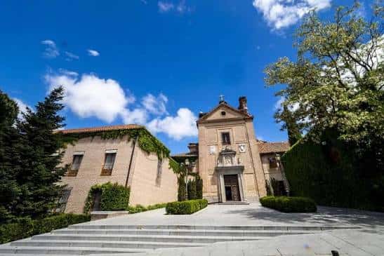 Exterior del convento con jardines bien cuidados y escalinata de acceso