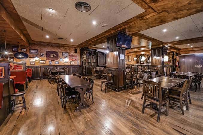 Interior del bar con mesas de madera y decoración rústica