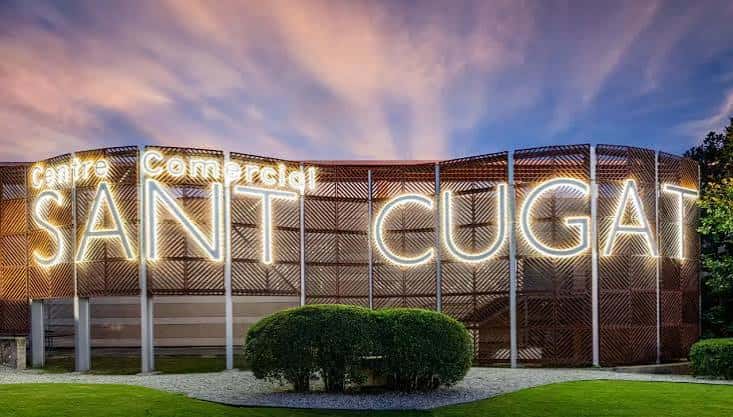 Fachada exterior del Centro Comercial Sant Cugat con letrero luminoso al atardecer