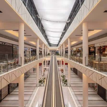 Vista interior del centro comercial mostrando pasarelas y escaleras mecánicas