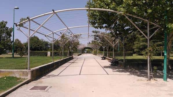 Pasarela con estructura metálica y arcos en el parque