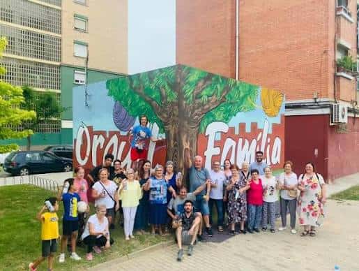 Grupo de personas frente al mural comunitario 'Granollers Família' en el centro cívico