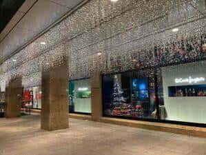 Interior del centro comercial con decoración navideña y escaparates iluminados