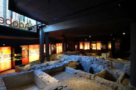 Interior del centro de interpretación L'Adoberia mostrando las ruinas arqueológicas iluminadas