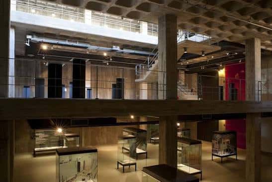 Vista panorámica del interior moderno del museo con estructuras de madera y vitrinas de exposición