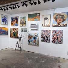 Interior de la galería con obras de arte expuestas en las paredes