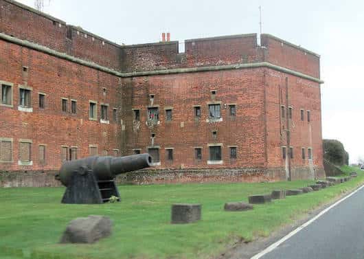 Vista lateral de la fortaleza de Fort Widley con un cañón histórico en primer plano