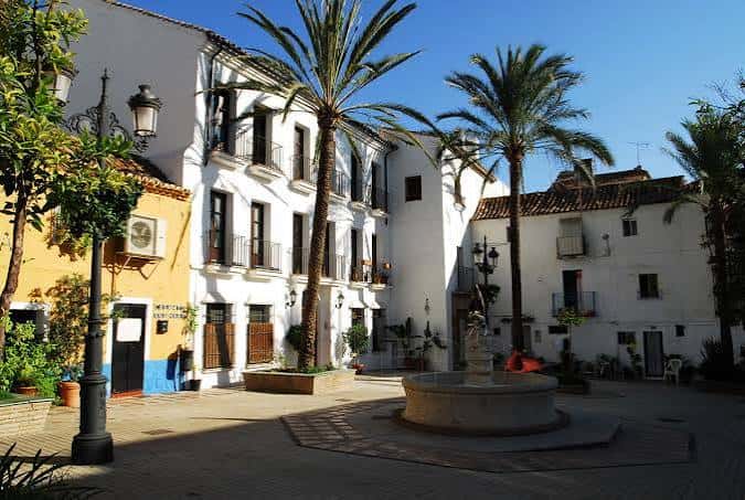 Plaza del Santo Cristo en Marbella con fuente central y palmeras bajo cielo despejado