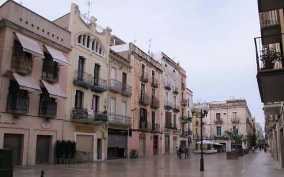 Vista panorámica de la Plaça de les Cols con edificios históricos y fachadas coloridas