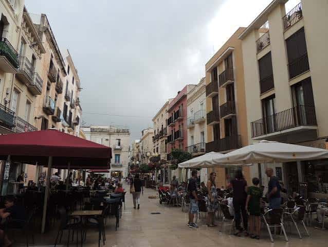 Plaza animada con terrazas de cafeterías y personas disfrutando del ambiente urbano