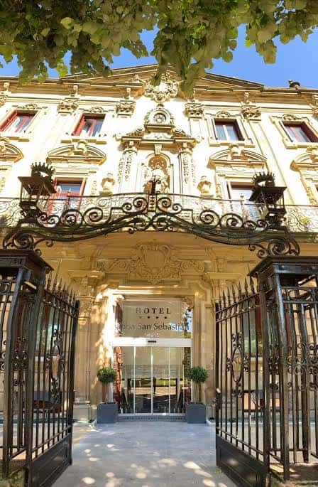 Fachada principal del Hotel Abba San Sebastián con entrada ornamentada y portones de hierro