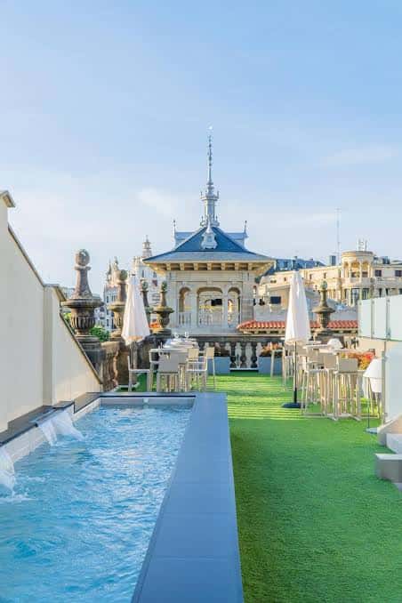 Piscina en terraza con césped artificial y mirador arquitectónico al fondo